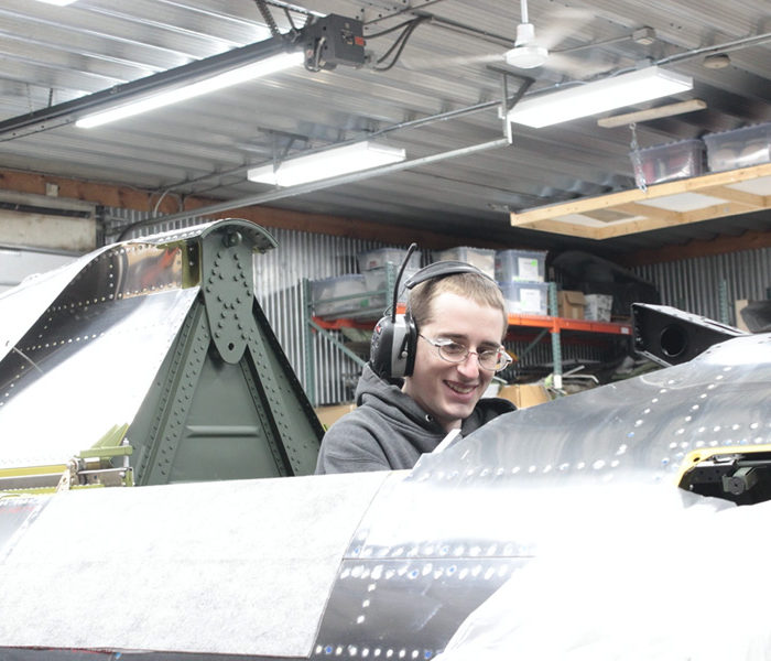 Aaron works at system installation in the P-47 cockpit.