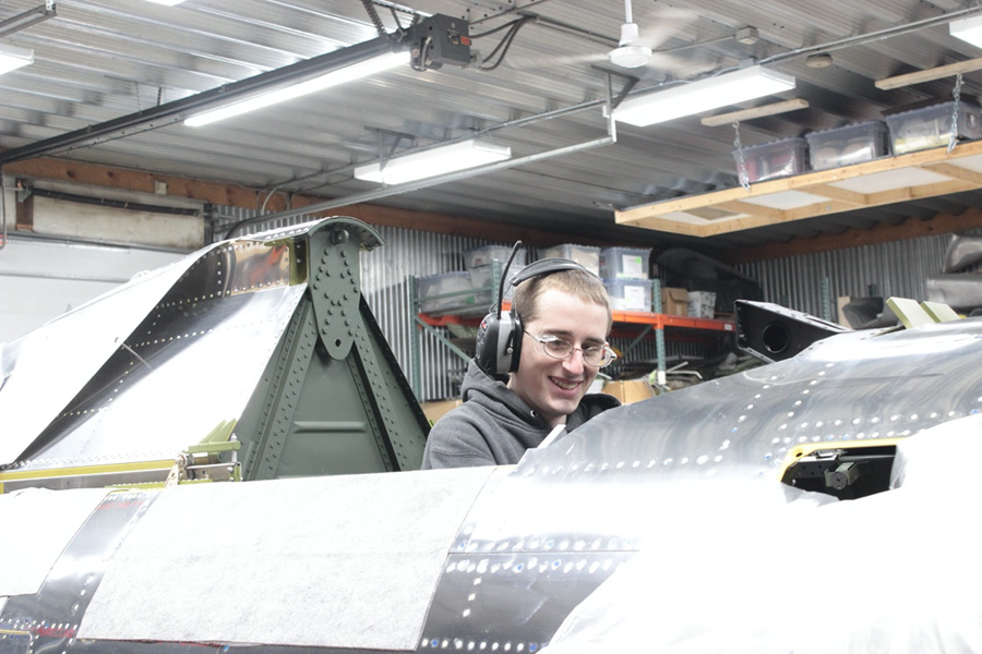 Aaron works at system installation in the P-47 cockpit.