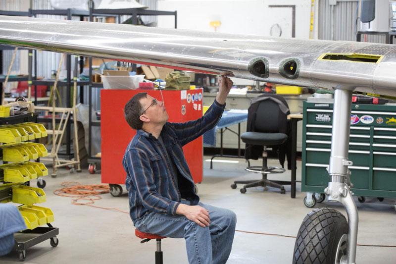 Mark examines the jack point. Here another difference between the B and C models and the later Ds is visible.  The photo shows the two gun ports in each wing of the C model instead of the more familiar P-51Ds with three guns in each wing.