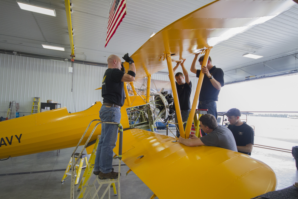 From left Brian, Simon, Erik, Mark (lower) and Sam work to rig the Stearman