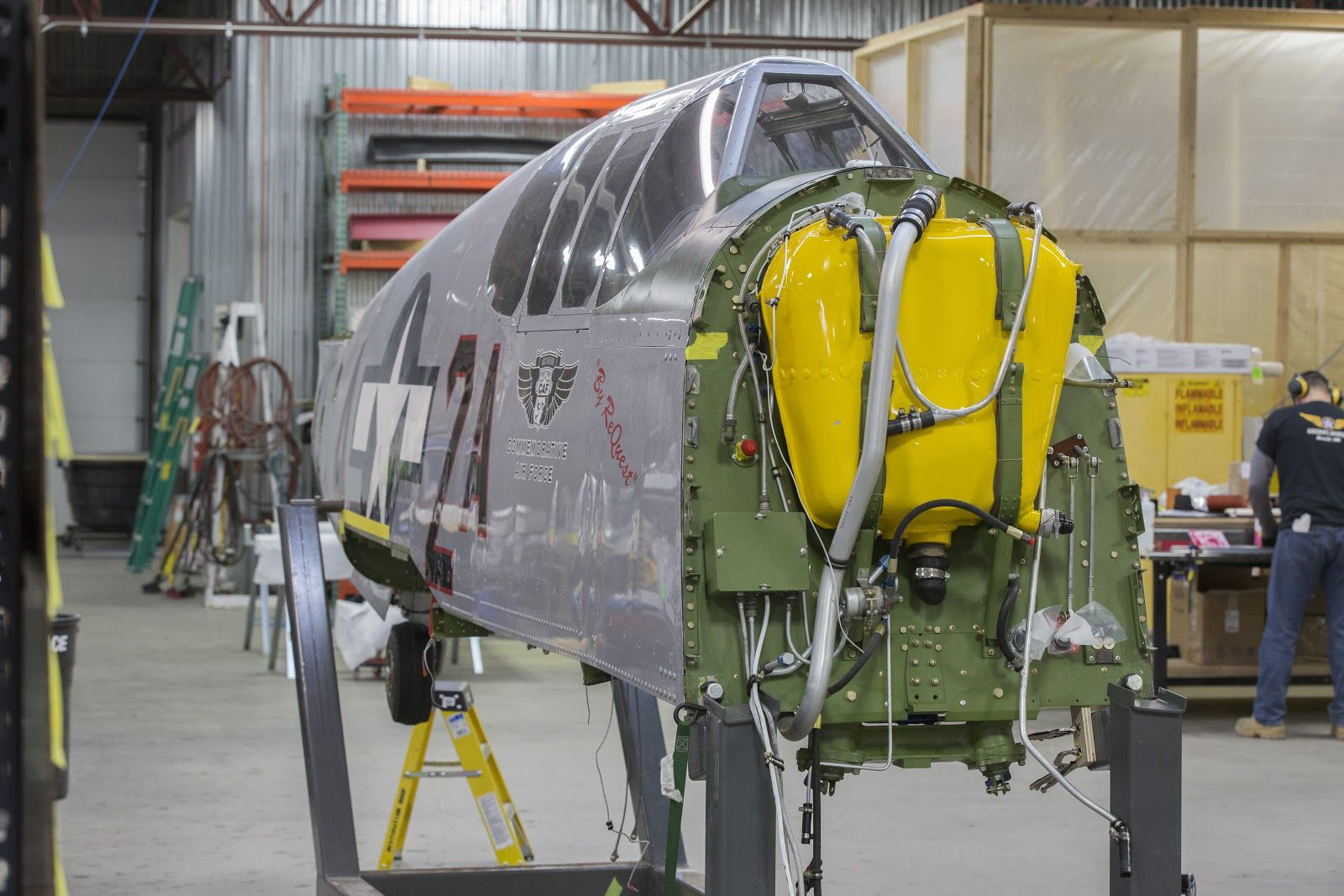 This is a front view of fuselage in the fixture inside the restoration shop working area.